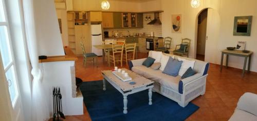 ein Wohnzimmer mit einem Sofa und einem Tisch in der Unterkunft Pine Trees and Sea View Houses in Hydra - Daphne, Chloe, Myrto, Eleni in Hydra