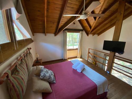 a bedroom with a couch and a ceiling fan at Complejo de Cabañas Tunquelen in Mar de las Pampas