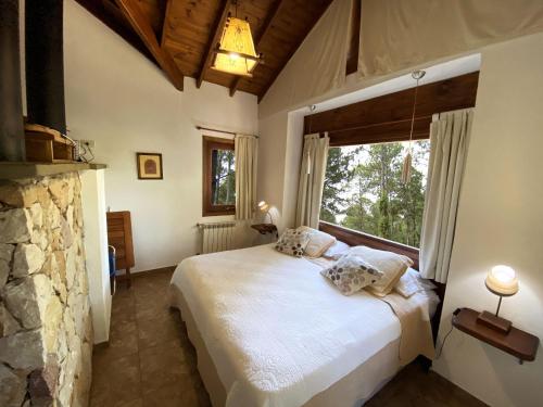 een slaapkamer met een bed en een groot raam bij Complejo de Cabañas Tunquelen in Mar de las Pampas