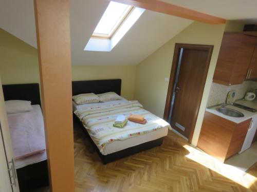 ベオグラードにあるHotel Apartments Bella Mare Belgradeのベッドルーム1室(ベッド1台、シンク、天窓付)