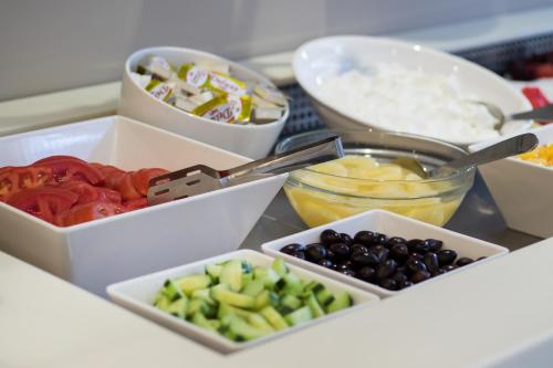 a table topped with bowls of different types of vegetables at Parasol Luxury Hotel & Suites Adults Only in Karpathos Town