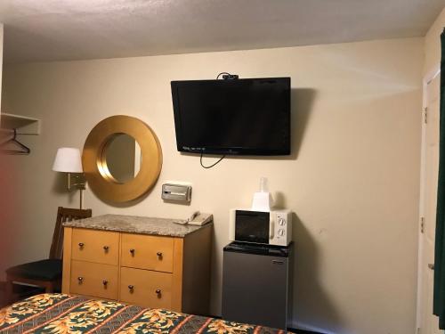 a hotel room with a bed and a tv on the wall at Budget Inn Parker in Parker