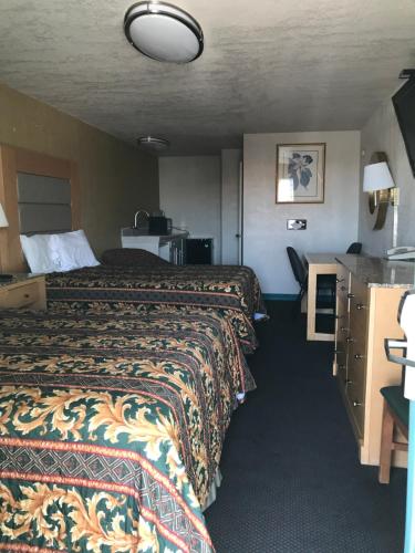 Habitación de hotel con 2 camas y mesa en Budget Inn Parker, en Parker