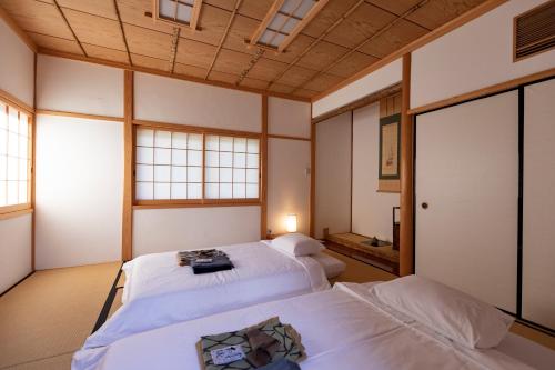 two beds in a room with windows at Kannawaen in Beppu
