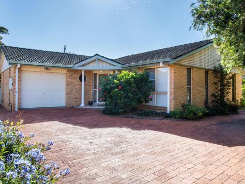 a brick house with a driveway in front of it at 1/4 Huntly Close in Tuncurry