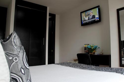 Una televisión o centro de entretenimiento en Hotel Santafe Real