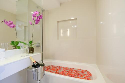 a bathroom with a shower with a tub with red balls in it at Quest Hotel & Conference Center Cebu in Cebu City