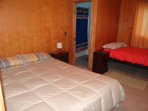 a bedroom with two beds and a window at Hostal Santa Fe in Castro