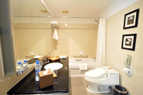 Gubei Garden Hotel Shanghai Hongqiao في شانغهاي: حمام به مرحاض أبيض ومغسلة