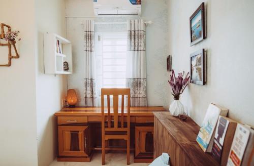 a desk in a room with a chair and a table at ngaunhien's house - Homestay in Thôn Dư Khánh
