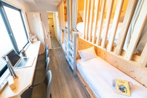 a small room with a bed and a laptop at ZAITO Tokyo Kinshicho Economy Inn 宅东东京横川1民宿 in Tokyo