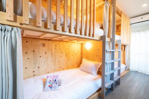 a bunk bed in a room with a ladder at ZAITO Tokyo Kinshicho Economy Inn 宅东东京横川1民宿 in Tokyo