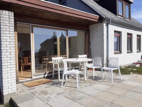 a table and chairs on a patio with a table and windows at Svendborg Cosy in Svendborg