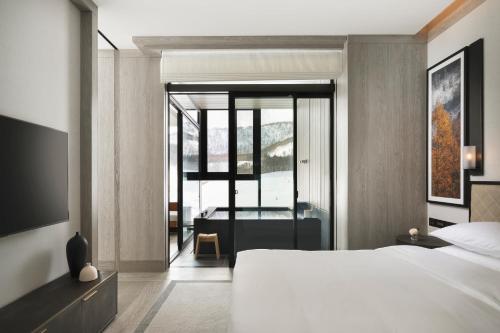 a bedroom with a bed and a view of a bathroom at Park Hyatt Niseko Hanazono in Kutchan