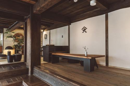 a room with a wooden table and a bench at NIPPONIA Kosuge Village in Kosuge