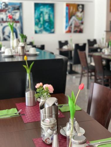 a table with vases of flowers in a restaurant at Hotel Stay in Essen