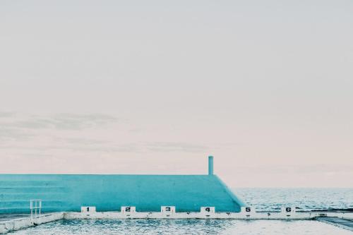 a blue building sitting on top of the water at Novotel Newcastle Beach in Newcastle