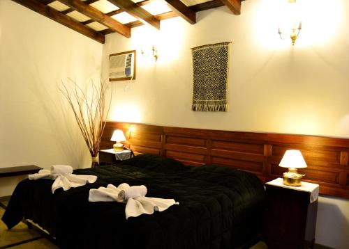1 dormitorio con 1 cama grande y 2 toallas blancas en Golden Lodge en Paso de la Patria