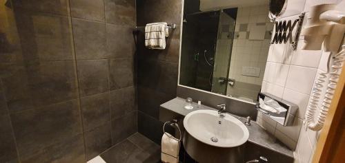 a bathroom with a sink and a mirror at Hotel Ifen in Wiesloch