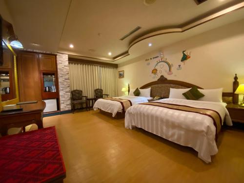 a hotel room with two beds and a red rug at Wenpin Hotel - Pier 2 in Kaohsiung