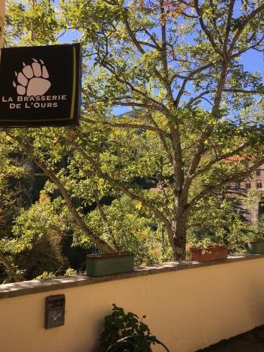 a sign on a wall with trees in the background at Hôtel Val Du Tech in Prats-de-Mollo-la-Preste