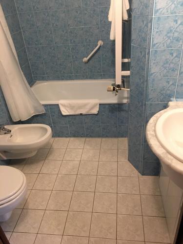a bathroom with a tub and a toilet and a sink at Hôtel Val Du Tech in Prats-de-Mollo-la-Preste