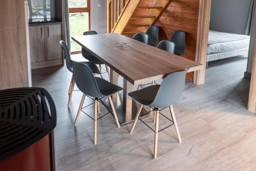 a wooden table and chairs in a room at Camping Base de Loisirs du Lac de la Moselotte in Saulxures-sur-Moselotte