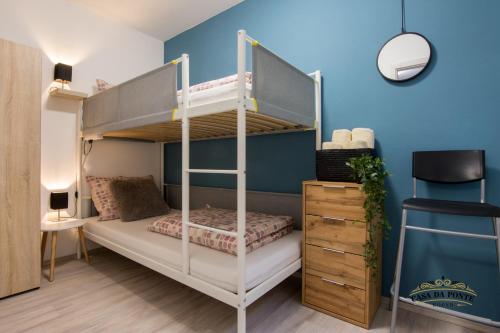 a bedroom with a bunk bed and a blue wall at Casa Da Ponte in Koper