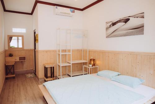 a bedroom with a large white bed and a desk at ngaunhien's house - Homestay in Thôn Dư Khánh