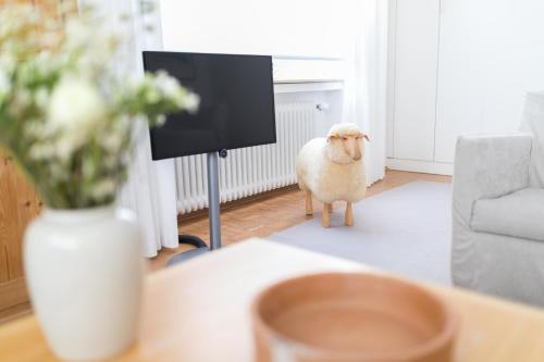 a sheep is standing in a living room at Vier Häuser in Norderney