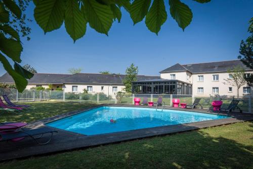 a swimming pool in the yard of a house at The Originals City, Hôtel La Saulaie, Saumur Ouest (Inter-Hotel) in Doué-la-Fontaine