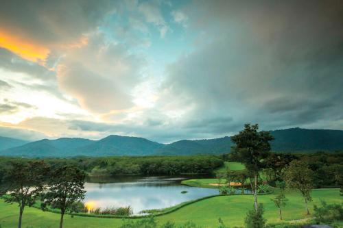 a view of a lake with mountains in the background at Kirimaya Golf Resort Spa - SHA Plus Certified in Mu Si