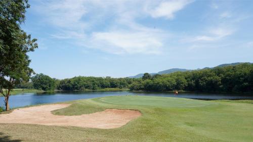 a golf course with a view of a lake at Kirimaya Golf Resort Spa - SHA Plus Certified in Mu Si