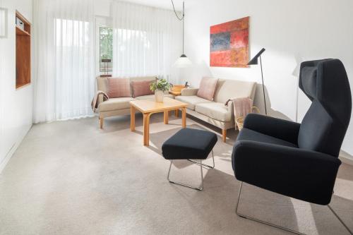 a living room with a couch and chairs and a table at Vier Häuser in Norderney