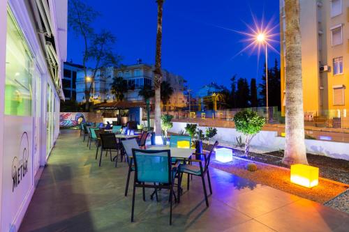 a row of tables and chairs on a patio at night at Mene City Hotel in Antalya