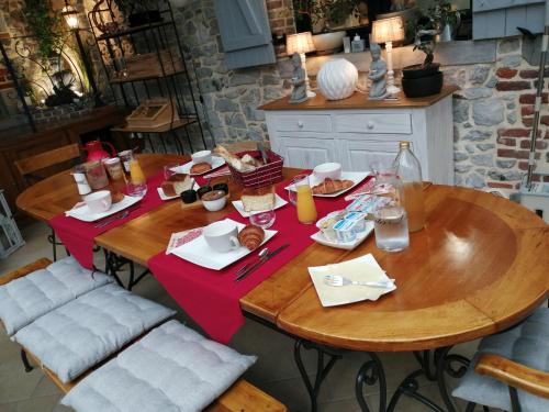 2 mesas de madera con comida en la cocina en La Parenthèse Avesnoise, en Limont-Fontaine