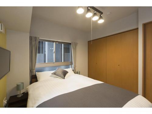 Un dormitorio con una cama grande y una ventana en Coruscant Hotel Nagasakieki, en Nagasaki