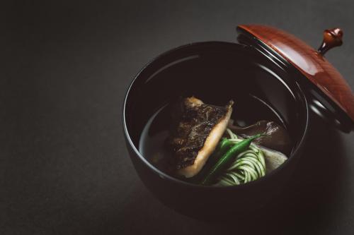 a black bowl of food with vegetables in it at NIPPONIA Kosuge Village in Kosuge