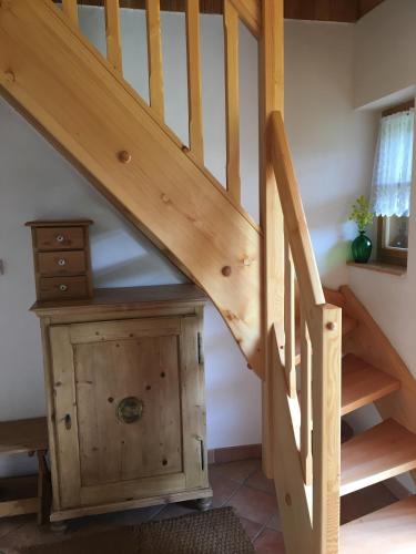 a wooden staircase with a wooden cabinet under it at Šumavská roubenka in Vacov