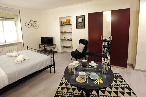 um quarto com uma cama e uma mesa com copos e pratos em Cozy studio in Turin city center by Wonderful Italy em Turim