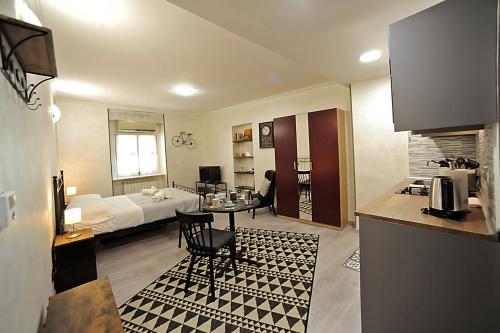 uma sala de estar com uma cozinha e uma sala de estar com um sofá em Cozy studio in Turin city center by Wonderful Italy em Turim