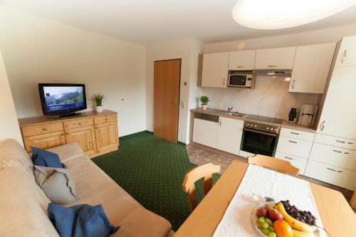 a living room with a couch and a table with a bowl of fruit at Urlaubsland Sonnfeld in Flachau