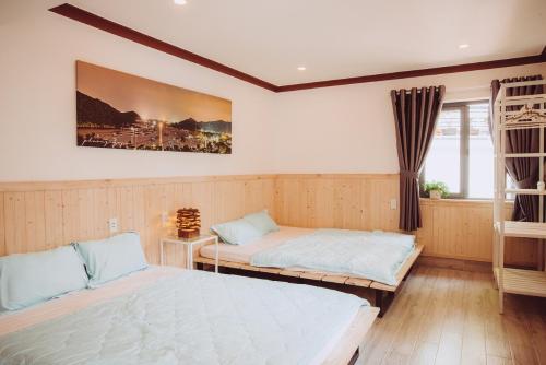 a bedroom with two beds and a window at ngaunhien's house - Homestay in Thôn Dư Khánh