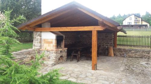 a stone fireplace with awning on top of it at Šumavská roubenka in Vacov
