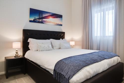 a bedroom with a large bed with a picture on the wall at Axis - Century City Self Catering Apartment in Cape Town