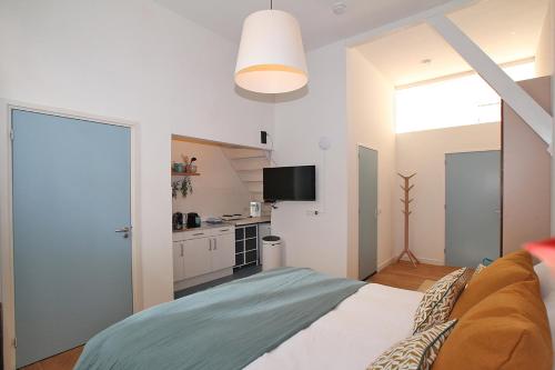 a bedroom with a large bed and a kitchen at Citystays Deventer in Deventer