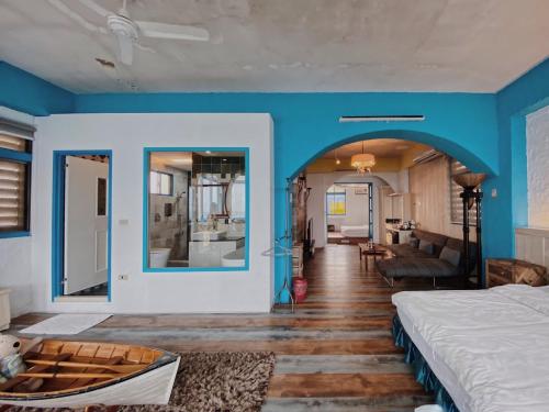 Cette chambre comprend un lit et un mur bleu. dans l'établissement Near Seaside B&B, à Hualien