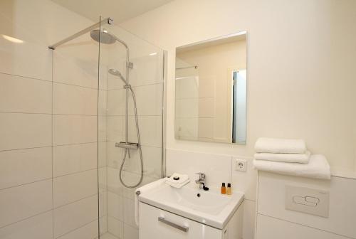a white bathroom with a shower and a sink at Citystays Deventer in Deventer