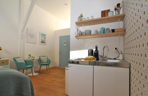 a kitchen with a sink and a table in a room at Citystays Deventer in Deventer