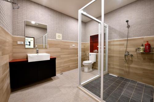 W łazience znajduje się prysznic, umywalka i toaleta. w obiekcie Windsor's Vanilla Garden B&B w mieście Jiufen